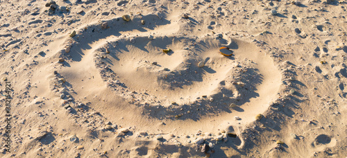 Swirling spiral pattern on the sand with footprints on Cape Cod beach. Panoramic grunge image for backgrounds.