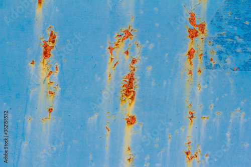 Rusty blue metal wall. Blue metal background with spots and streaks of rust. There are rust spots on the metal surface.
