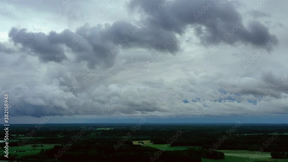 Aerial hyperlapse view of a dark, storm clouds moving on a windy sky, in rural Finland - pan, drone time lapse shot Aerial hyperlapse view of a dark, storm clouds moving on a windy sky, in rural Finland - pan, drone time lapse shot
