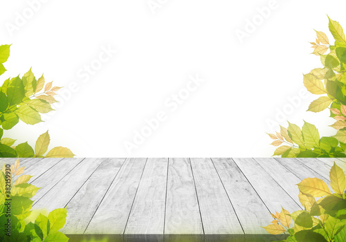 white wooden table top with spring green leafs as frame and free space for te...