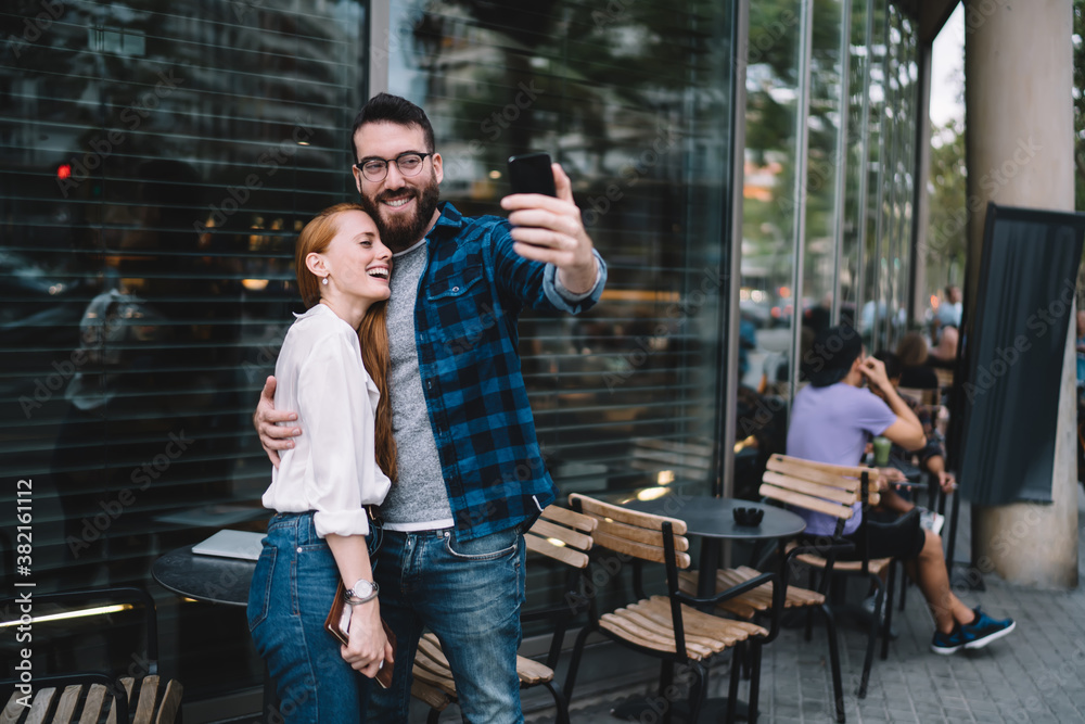 Smiling couple taking selfie near cafe Smiling couple taking selfie near cafe