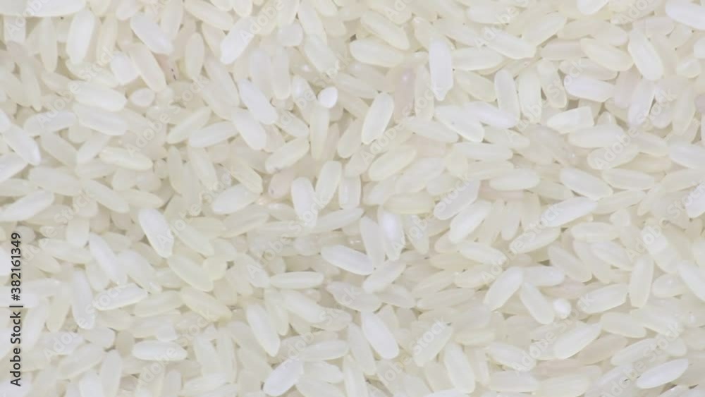 raw uncooked rice long grain spinning close-up raw uncooked rice long grain spinning close-up