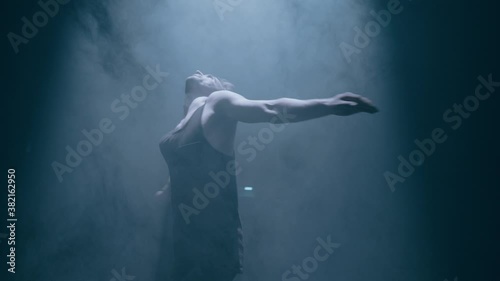 Wallpaper Mural Young attractive man dancer is spinning around on dark smoke background Torontodigital.ca