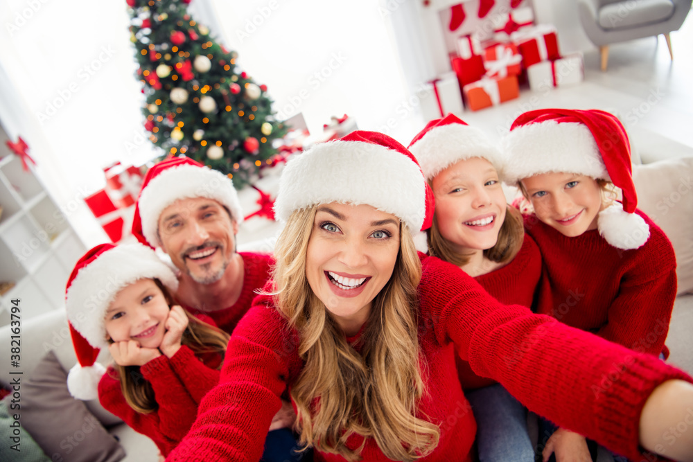 Full family x-mas eve tradition event. People mom dad three preteen little kids make selfie chatting relatives wear santa claus hats in house with christmas noel decoration Full family x-mas eve tradition event. People mom dad three preteen little kids make selfie chatting relatives wear santa claus hats in house with christmas noel decoration