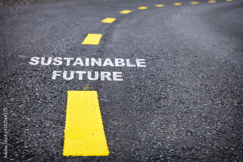 Sustainable future word on asphalt road surface with marking lines. Inspiration and motivation concept and effort idea
