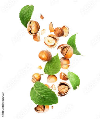 Crushed hazelnuts with leaves on a white background photo