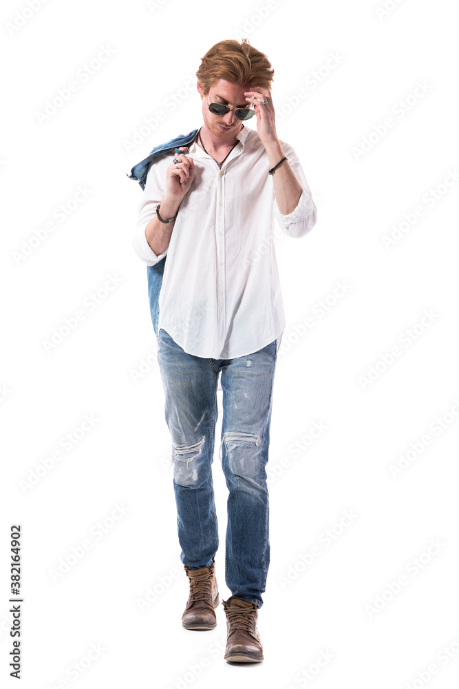 Sad worried thoughtful young man walking and scratching head looking down. Full body isolated on white background. Sad worried thoughtful young man walking and scratching head looking down. Full body isolated on white background.
