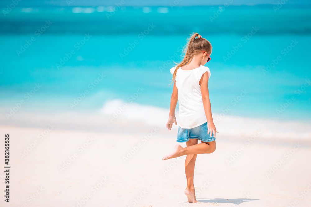 Adorable active little girl at beach during summer vacation Adorable active little girl at beach during summer vacation