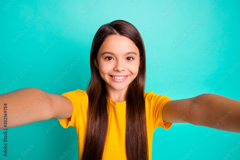 Photo of positive little kid girl make selfie wear casual style clothes isolated over teal color background Photo of positive little kid girl make selfie wear casual style clothes isolated over teal color background