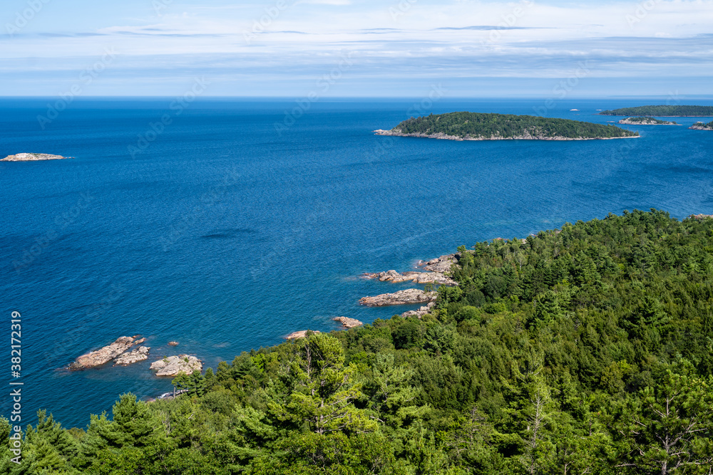 Blue waters of Lake Superior and rocky coastline atop mountain in Michigan