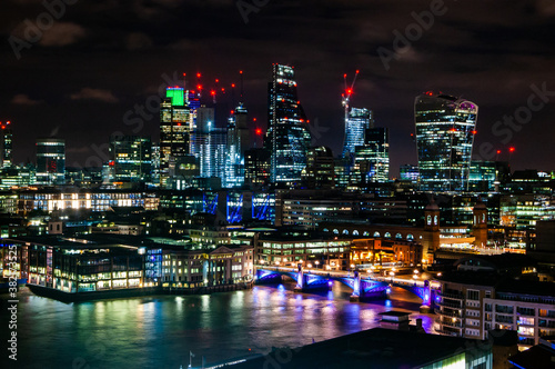Night cityscape skyline of London downtown with Thames river, famous bridges and modern business center skyscrapers on the background © YKD