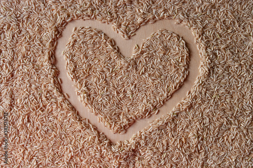 a heart sign on a brown rice background on plywood