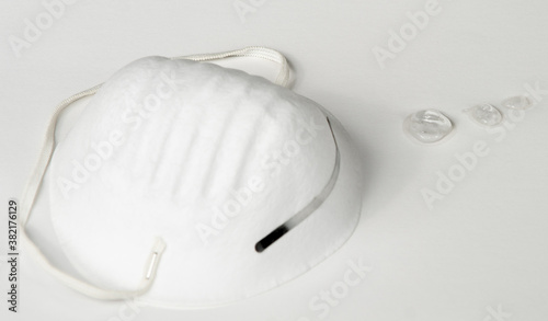 COVID PPE Mask and Hand Sanitizer Drops on White Background