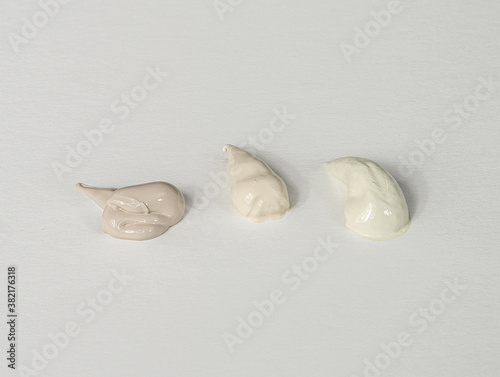 Acrylic paint dabs or dollops, beige, creamy white, taupe, on white background