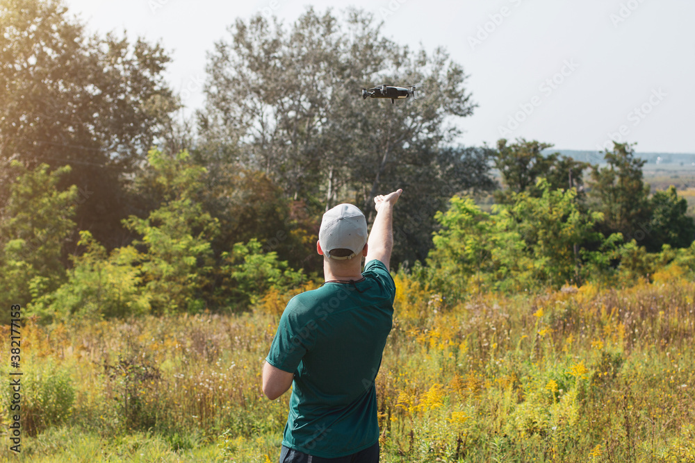 Back view of professional pilot man operating the drone by remote control Back view of professional pilot man operating the drone by remote control