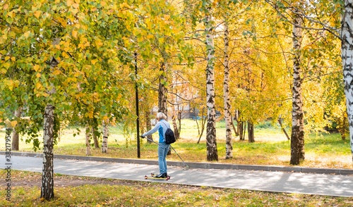 autumn in the park. elderly people in sports. An elderly woman is skiing in summer.