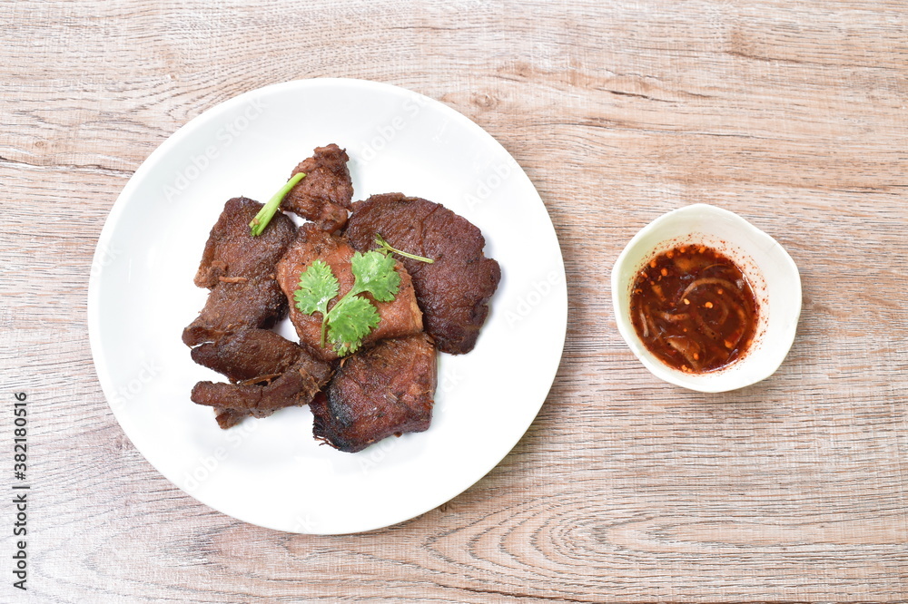 fried salty pork with garlic topping parsley on plate dipping spicy hili sauce cup fried salty pork with garlic topping parsley on plate dipping spicy hili sauce cup