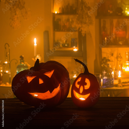 Halloween pumpkins with candles and magic potions at night indoor