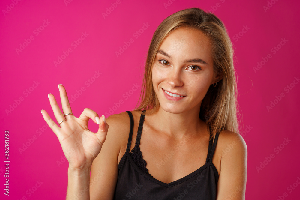Portrait of a cheerful young woman showing OK sign Portrait of a cheerful young woman showing OK sign