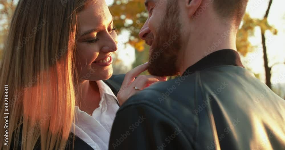 Close view of romantic girl caresses her bearded belover and kisses him outdoor Close view of romantic girl caresses her bearded belover and kisses him outdoor