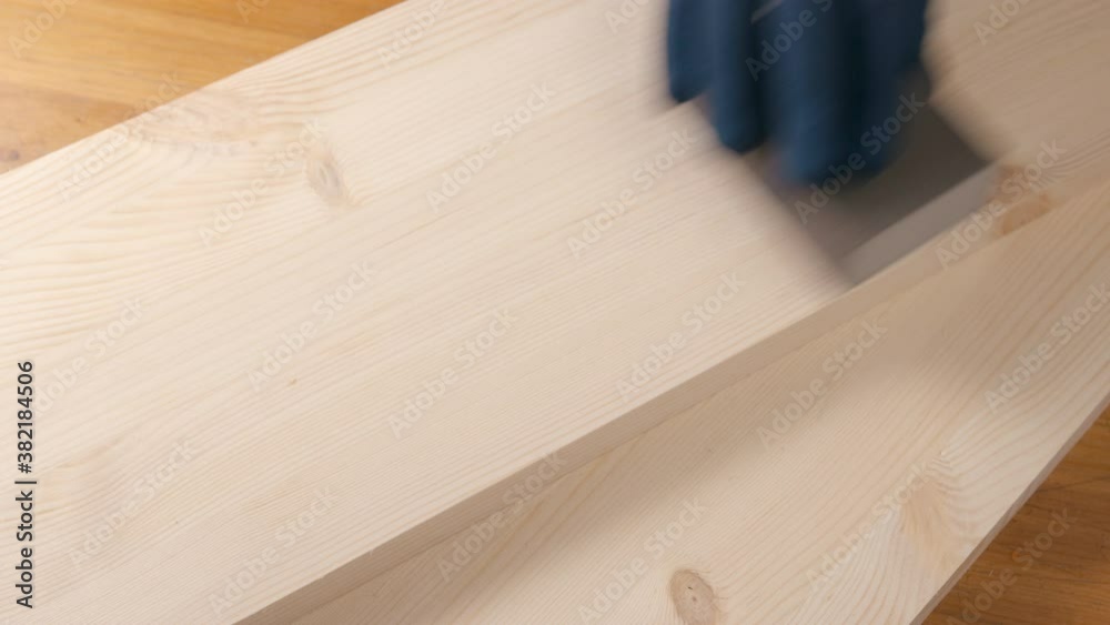 Untitled Project 3a man sanding a pine board with sandpaper
