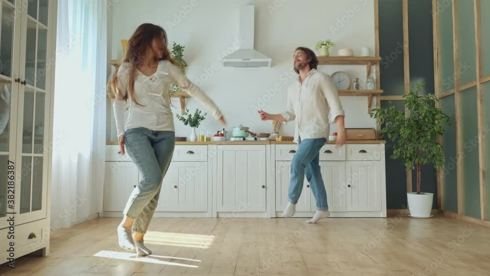 Lovely Couple Having a Fun Together While Dancing at the Bright Kitchen. Couple Dancing in Cozy Modern Kitchen at Home. Man and Woman Enjoy Spending Time Together. Lovely Couple Having a Fun Together While Dancing at the Bright Kitchen. Couple Dancing in Cozy Modern Kitchen at Home. Man and Woman Enjoy Spending Time Together.
