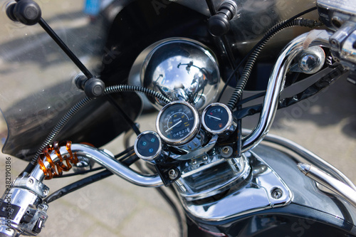 Motorcycle detail with gasoline tank, fuel level, speedometer and windshield. Chrome motorcycle details closeup. Narrow depth of field