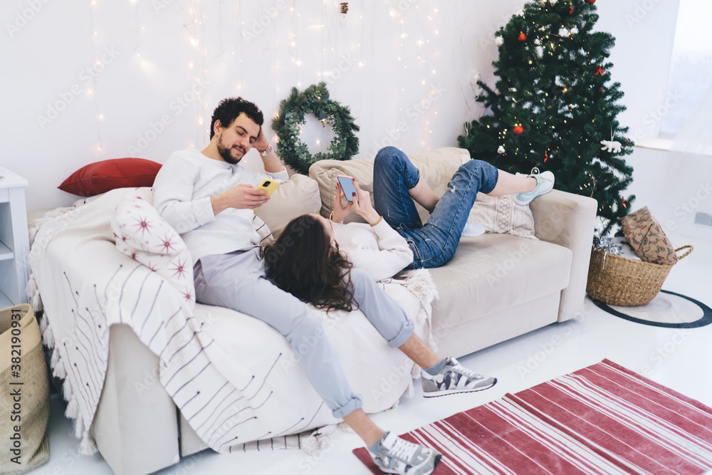millennial hipster girl and guy ignore communication resting on weekends during winter holidays at home, couple in love addicted to gadgets and social networks browsing staying silent