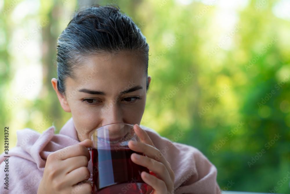 woman wrapped in blanket drinking hot brewed red tea. Tea for immunity, ingredients for the treatment of colds. woman wrapped in blanket drinking hot brewed red tea. Tea for immunity, ingredients for the treatment of colds.