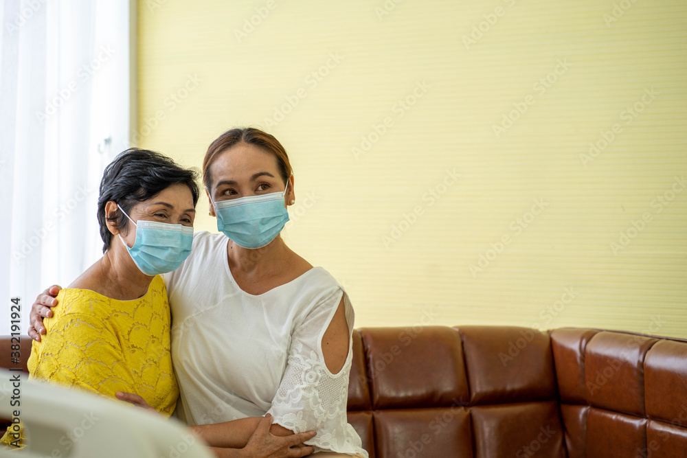 Senior Asian woman in hospital with daughter taking care with protective face mask. Health care and medicine concept. Senior Asian woman in hospital with daughter taking care with protective face mask. Health care and medicine concept.