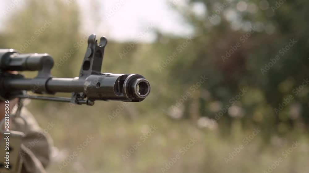 Shot of a bullet from an assault rifle Kalashnikov AK. Close-up of a flame arrestor. Super slow motion.