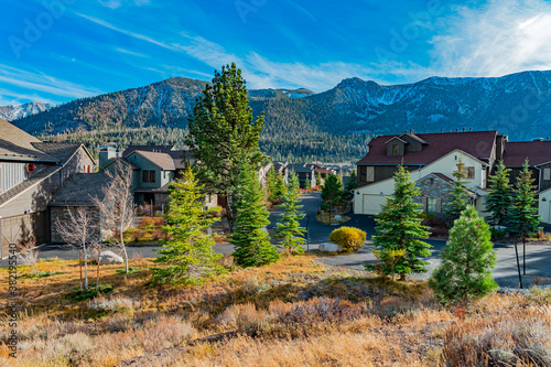 Mammoth Lakes, California is filled with homes and pine trees and snow covered mountains in the fall.