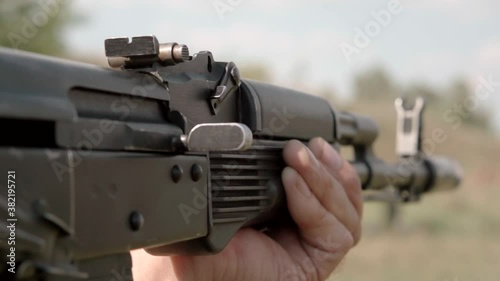 Shooting from an assault rifle Kalashnikov AK. Shot out cartridge case flies out of the chamber. Close-up. Super slow motion.