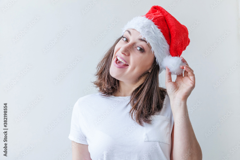 Beautiful girl in red Santa Claus hat isolated on white background looking happy and excited. Young woman portrait, true emotions. Happy Christmas and New Year holidays Beautiful girl in red Santa Claus hat isolated on white background looking happy and excited. Young woman portrait, true emotions. Happy Christmas and New Year holidays