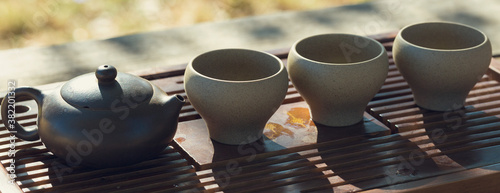 Panel kuchenny z motywem Chinese tea ceremony. Ceramic teapot made of clay and bowls on a wooden background.