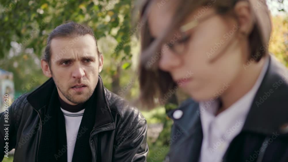Quarrel of a young love couple. The boyfriend emotionally expresses his claims to his girlfriend. Rough emotional talking. Concept of people and emotions. Quarrel of a young love couple. The boyfriend emotionally expresses his claims to his girlfriend. Rough emotional talking. Concept of people and emotions.