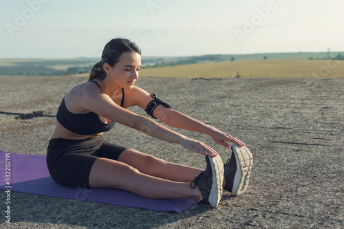 Young attractive woman doing exercise working out outdoors.