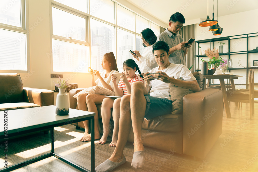 Obraz premium Social media addiction concept, Everyone in family using mobile phone in the living room. Problem of family relationships from mobile phone addiction. Family in no quality concept. introvert society.