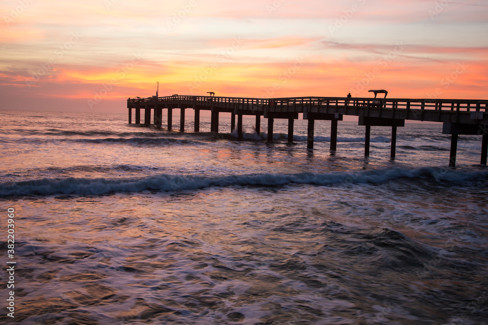 Sunrise through a fishing pier  at the beach at St Augustine, Florida.