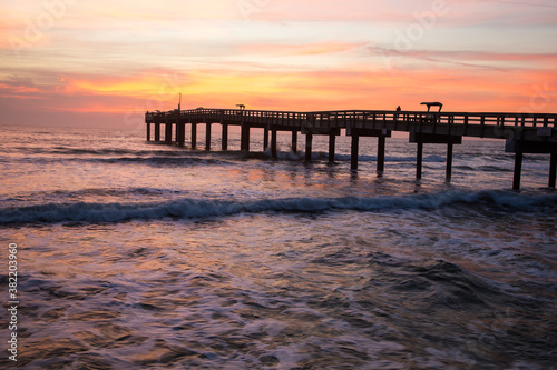 Sunrise through a fishing pier  at the beach at St Augustine  Florida.