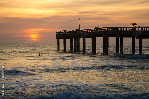 Sunrise through a fishing pier at the beach at St Augustine, Florida.
