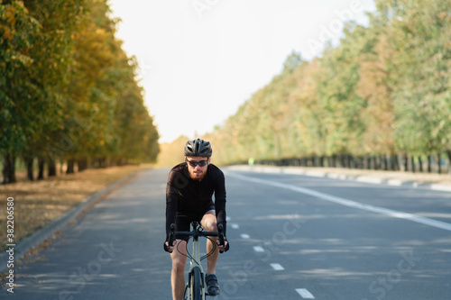 Fototapeta Naklejka Na Ścianę i Meble -  Road cyclist exercising on a gravel bike. Bicycle training outdoors, modern looking bike and sportsman, happy and active lifestyle