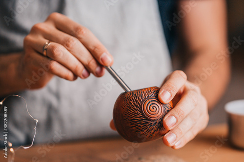 The process of brewing mate - a portion of dried leaves with a spoon in a calabash photo