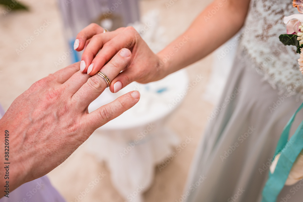Close up view of ring exchange at the wedding ceremony on the paradise beach, Punta Cana, Dominican Republic 