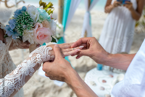 Fotografia Close up view of ring exchange at the wedding ceremony on the paradise beach, Pu