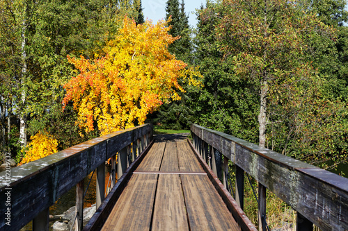 Wooden footbridge leading to the island. Colorful autumn landscape.