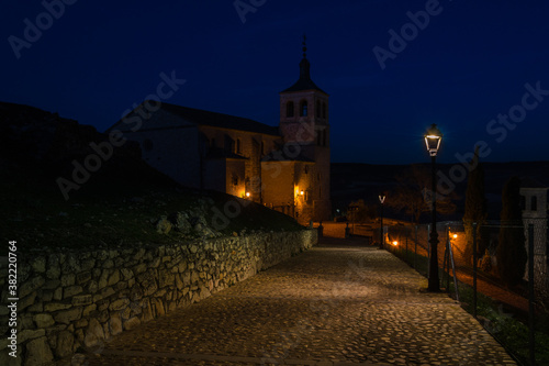 Illuminated street of the village of Cogolludo at night with the church in the background, Guadalajara, Spain
