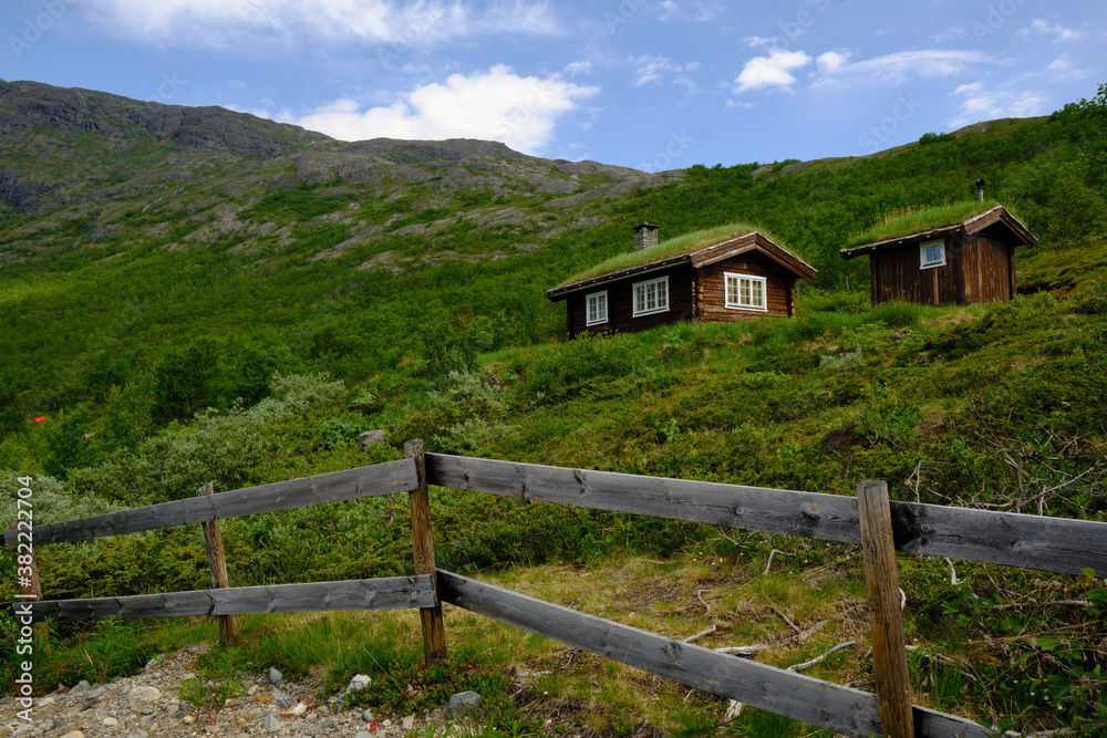 A red log cabin with traditional grass roof in Norway