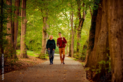 Beautiful woman,blonde,middle-aged,walking with her big son , autumn in the Park,Sunny day.