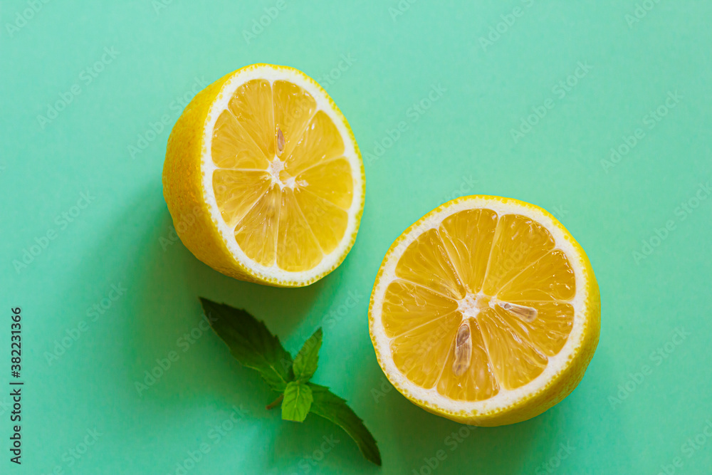 Two halves of fresh lemon on a green background, top view. Two halves of fresh lemon on a green background, top view.